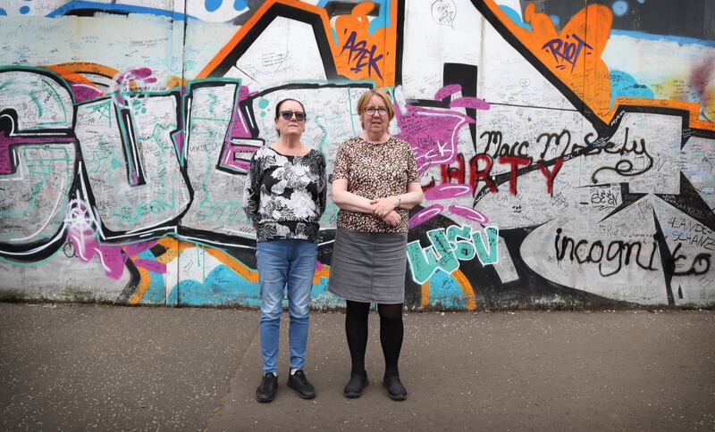 Patsy (right) and Jean Canavan pictured by the Peace Wall on the Cupar Way side, the Loyalist side of the wall,  behind their homes in Bombay Street. Photo: Bryan O’Brien

