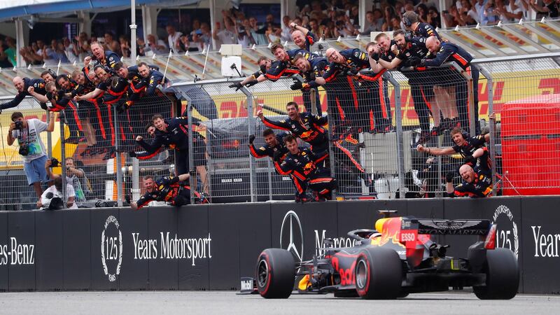 Max Verstappen crosses the line to win the race as Red Bull engineers celebrate. Photograph:  Kai Pfaffenbach/Reuters