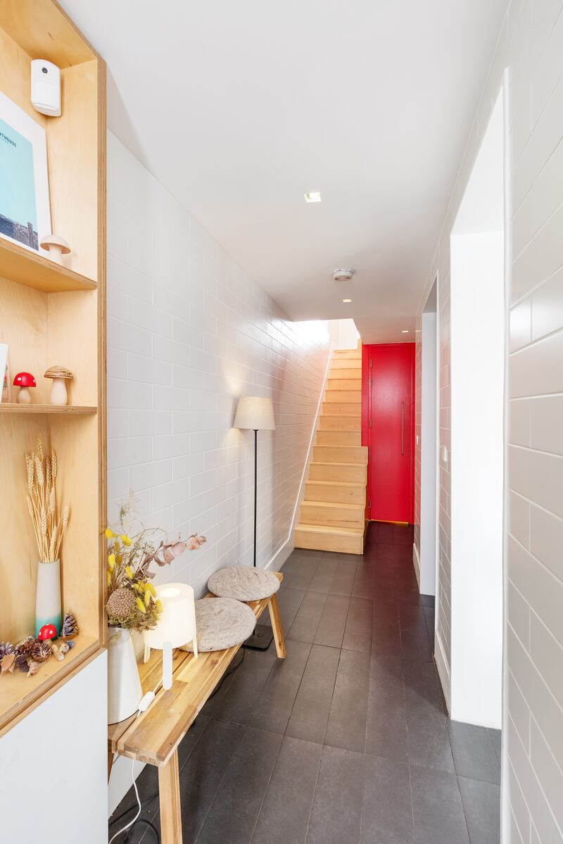 The entrance hall walls feature white metro tiles, creating a sleek effect