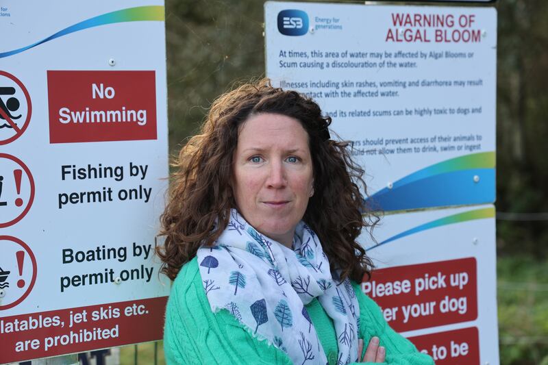 Elaine McGoff of An Taisce, at a sign from the ESB at Poulaphouca Reservoir warning of the hazards of algal bloom.  Photograph: Nick Bradshaw for The Irish Times