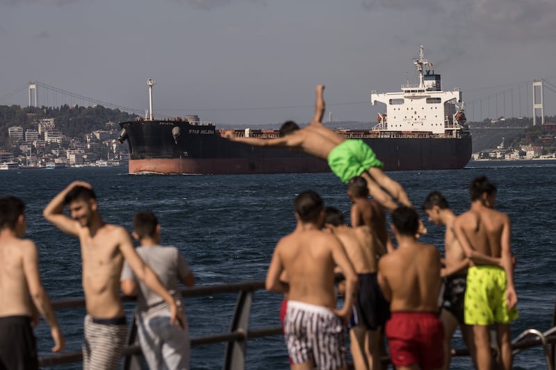 A man dives into the Bosphorus for a swim in Istanbul in front of the Marshall Islands flagged Star Helena after its departure the Ukrainian port of Chornomorsk. Vessels loaded with grain continue to depart from the Ukrainian ports of Odesa and Chornomorsk under the Black Sea Grain Initiative signed on the July 22nd. Photograph: Chris McGrath/Getty Images