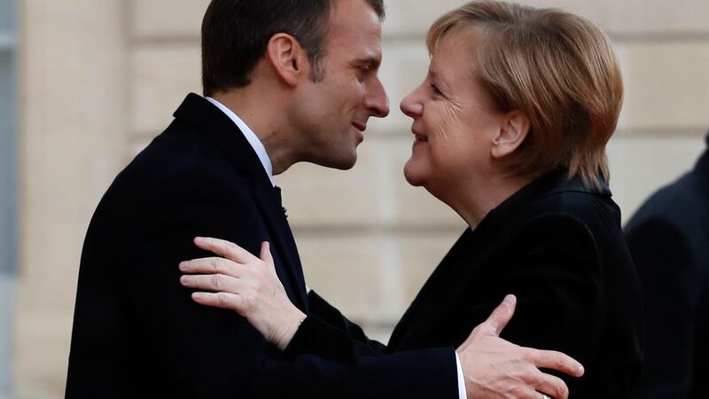 French president Emmanuel Macron hugs German chancellor Angela Merkel in Paris as the 100th anniversary of the end of first World War is marked. Photograph: Thibault Camus