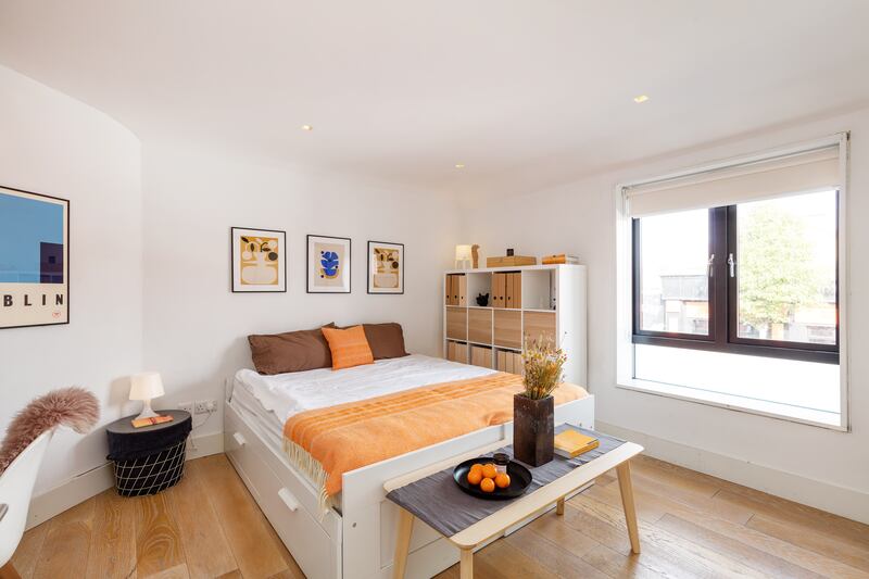 Another large double bedroom with built-in storage and shelving faces on to the street