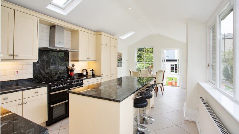 The kitchen/dining extension feels fresh, thanks to large windows to the right, skylights to the left and a tall sash window and glass garden door at the dining end