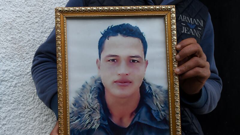 Walid Amri (at back), poses in recent days with a portrait of his brother,   Anis Amri (24), the prime suspect in Berlin’s deadly pre-Christmas truck attack. File photograph: Fethi Belaid/AFP/Getty Images