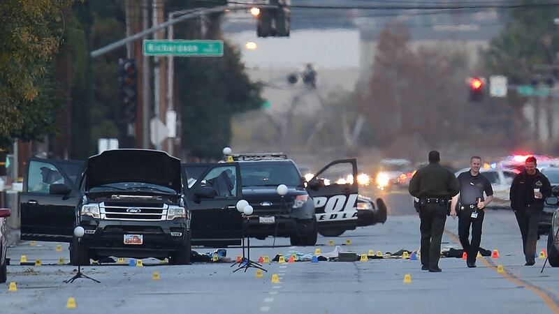Law enforcement officials continue their investigation around the Ford SUV vehicle that was the scene where suspects of the shooting at the Inland Regional Center were killed in San Bernardino, California. Photograph:  Joe Raedle/Getty Images