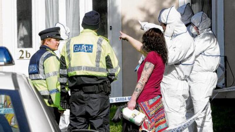 Gardaí speak to local people at the murder scene in March 2011.