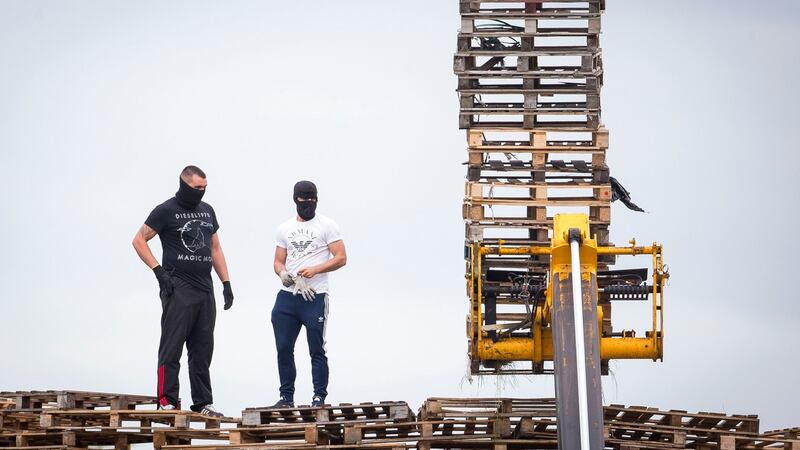 Masked men continue to build a bonfire at Inverary Playing Fields in Belfast on Monday. Photograph: Liam McBurney/PA Wire
