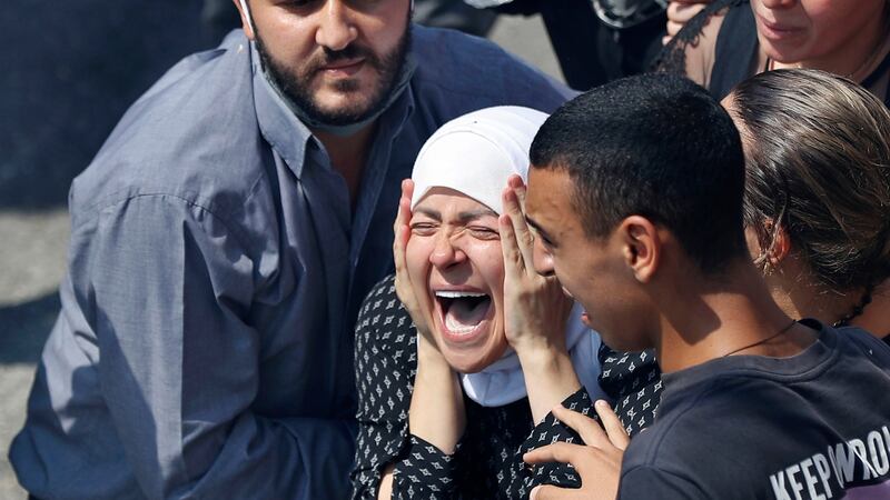 The wife of Rami Kaaki, one of ten firefighters who were killed during the last week's explosion that hit the seaport of Beirut, mourns during her husband's funeral at the firefighter headquarters, in Beirut, Lebanon, Tuesday, Aug. 11, 2020. (AP Photo/Hussein Malla)