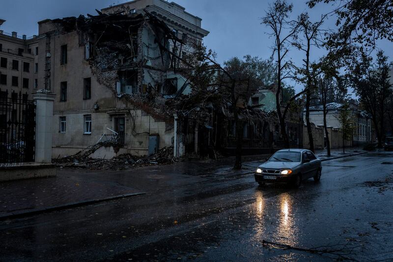 A car is driven past a damaged building on a nearly-deserted street in Kharkiv. Photograph: Ivor Prickett/The New York Times