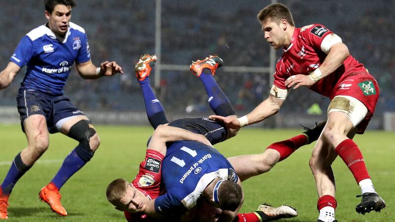 Fergus McFadden is tackled by Johnny Mcnicholl of Scarlets. Photo: Dan Sheridan/Inpho