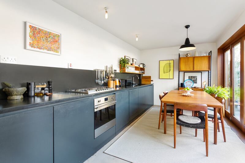 The sleek slate-grey handle-free units with Portuguese slate countertops and splashback in the kitchen are so contemporary and on-trend, it’s hard to believe they were installed in 2003.