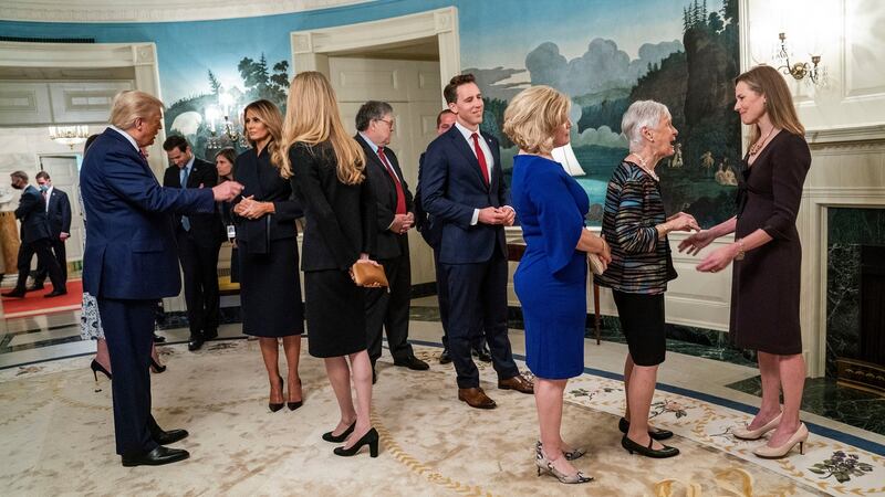 President Donald Trump, left, and Judge Amy Coney Barrett, far right,  in the Diplomatic Room of the White House in Washington, prior to making the announcement in the Rose Garden, on Saturday, September 26th. Few officials regularly wear masks in the White House. Photograph: Doug Mills/ The New York Times