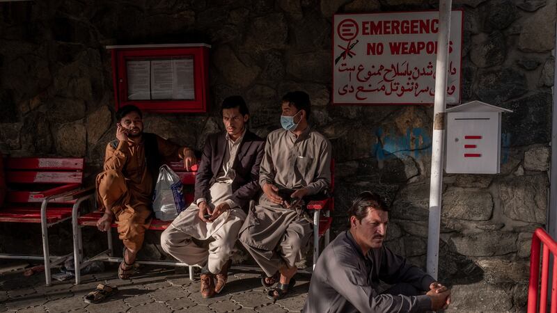 People sit outside a hospital in Kabul, Afghanistan on Friday, the day after a pair of suicide bombings outside the Kabul airport killed at least 85 people.  Photograph: Jim Huylebroek/The New York Times