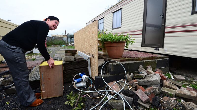Anne Connors shows exposed electric cables under a wooden box while work is being done on a sanitary unit at Labre Park halting site in Ballyfermot, Dublin. Photograph: Dara Mac Dónaill
