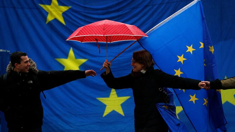 A man reaches for another participant as they dance in front of a giant European flag during the monthly pro-EU rally titled “Pulse of Europe” in Berlin. The citizens’ initiative was founded to encourage EU citizens to promote a “pan-European” identity. Photograph: Felipe Trueba/EPA
