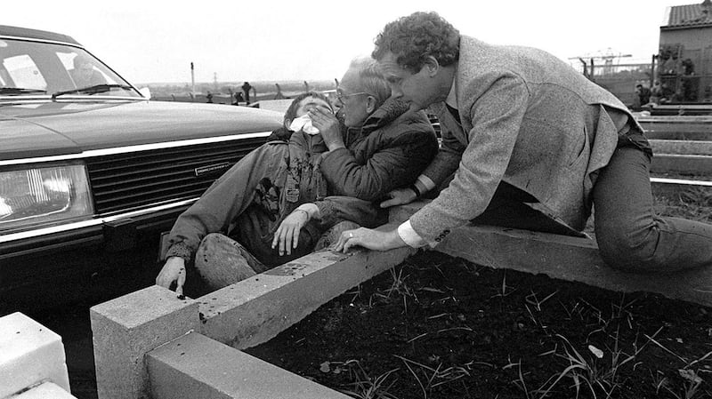 Martin McGuinness helps a young man shot in the face by  loyalist Michael Stone in Miltown cemetery in 1988. Photograph: Pacemaker Press