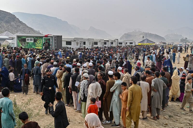 Afghan refugees gather around national database and registration authority vans for biometric verifications. Photograph: Farooq Naeem/AFP/Getty