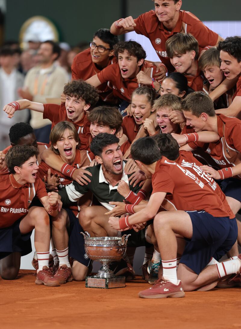 Carlos Alcaraz poses for a photo with the ball kids after his win over Jannik Sinner at the French Open. Photograph: Julian Finney/Getty Images