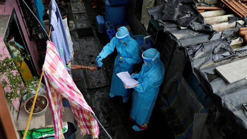 Health workers screen people for Covid-19 symptoms at Devnar slum in Mumbai, India. Photograph: Rajanish Kakade/ AP Photo