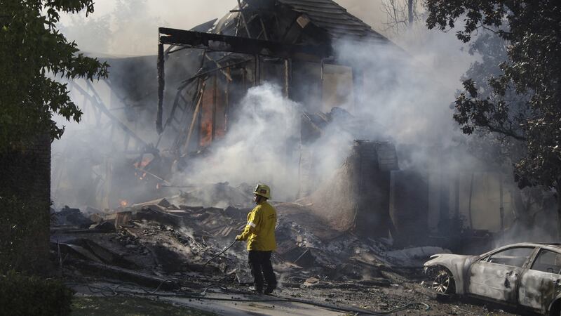 A firefighter inspects the smouldering ruins of a home destroyed in Agoura, California on November 9th, 2018. Photograph: Mike Nelson/EPA