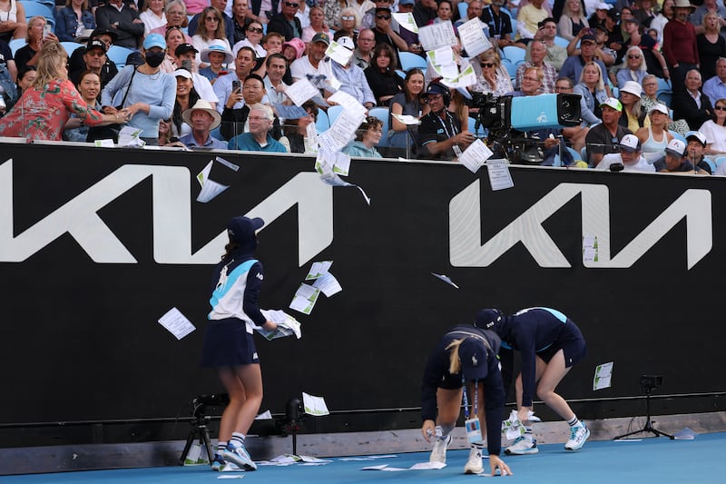 Ball kids clean up paper that was thrown onto Margaret Court Arena by the protestor. Photograph: Julian Finney/Getty Images