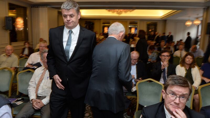 INM chief executive Robert Pitt (left) walks past chairman Leslie Buckley (back to camera) at the company’s AGM in Dublin. Photograph: Dara Mac Dónaill