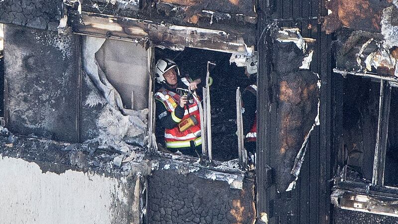 A firefighter investigates after a fire engulfed the 24-storey Grenfell Tower in west London. Photograph: Rick Findler/PA Wire
