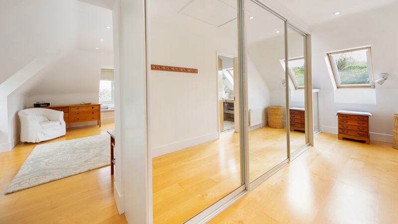 The main – partly under-eaves – bedroom is triple aspect, with a large dressing area with mirrored sliderobes and a fully-tiled en suite
