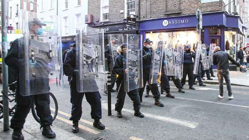 Gardaí with riot shields move in to disperse crowds on South Anne Street south in Dublin city. Photograph: Damien Storan