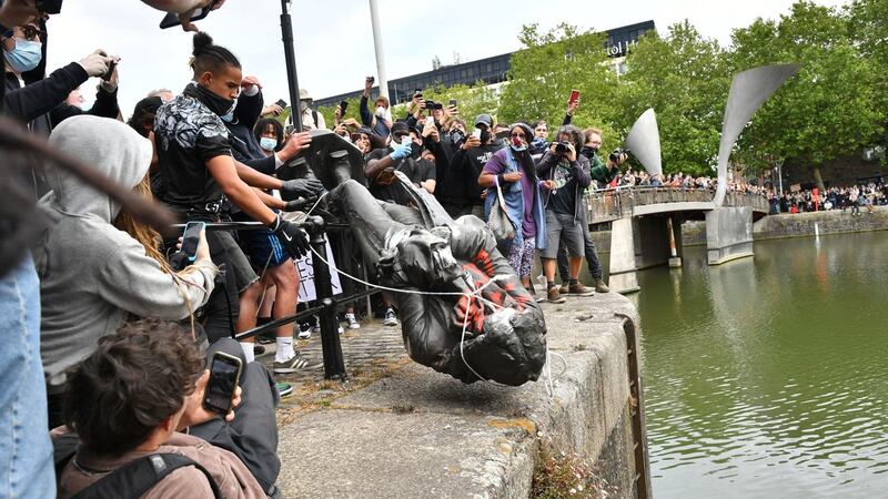 Protesters throw statue of Edward Colston into Bristol harbour during a Black Lives Matter protest rally on Sunday. Photograph: Ben Birchall/PA Wire