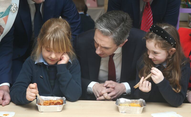 Taoiseach Simon Harris with students Summer Heart (7) and Anna McZorek (7) at the roll-out of the hot school meals programme. Photograph: Stephen Collins/Collins Photos

