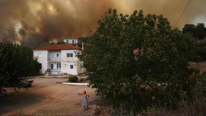 A woman speaks to media during a wildfire in Viliza village in the area of Ancient Olympia, Peloponnese, Greece. Photograph: Orestis Panagiotou/EPA