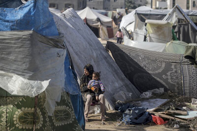 A Palestinian woman and a child,  who fled with their families from the northern Gaza Strip, outside their shelter in Deir Al Balah, Gaza Strip 