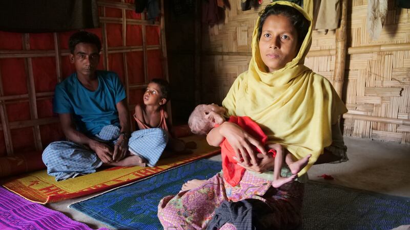 Rahima Khatun (30) holding her seven-month-old niece Taslima, whose mother died shortly after giving birth. In the background, her husband Muhammad Ali with one of their five other children, Sayedul Amin. Photograph: Kathleen Harris