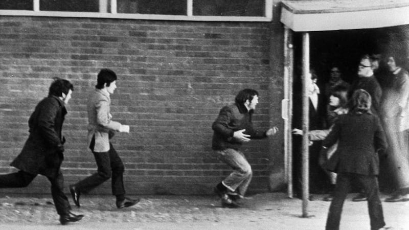 Hugh Gilmore, third left, clutching his stomach after being shot during Bloody Sunday. Photograph: PA/PA Wire