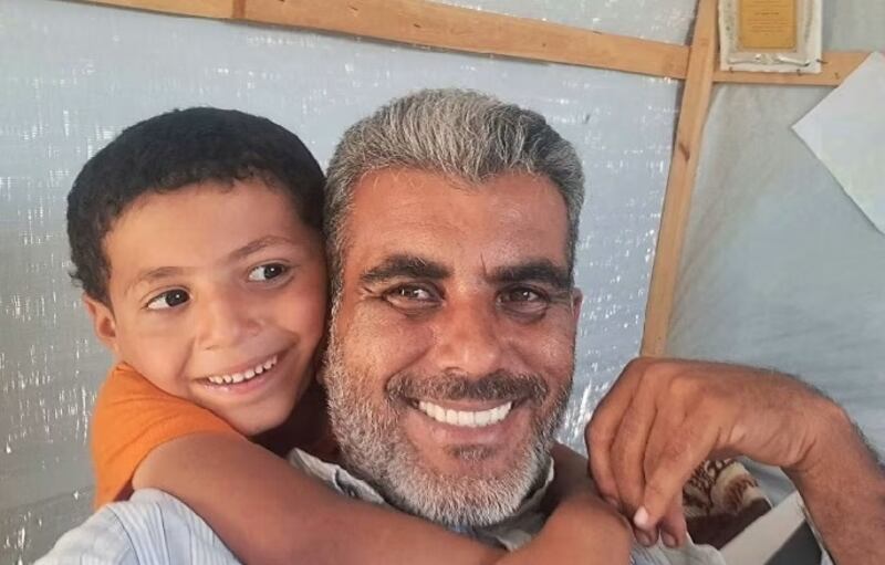 Mahmoud Kalakh with one of the children in the ‘orphan city’ which he set up after struggling to find shelter for his own family. Photograph: Financial Times