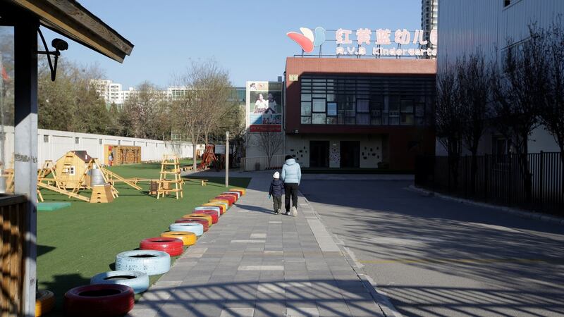 A child walks with a parent at the kindergarten run by pre-school operator RYB Education in Beijing, China. Photograph: Jason Lee/Reuters