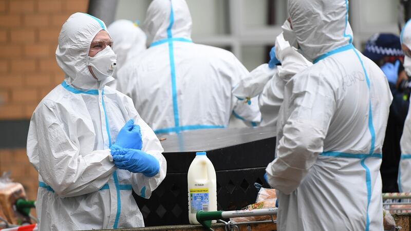 Firefighters dressed in personal protective equipment prepare to distribute food throughout a public housing tower in North Melbourne, Australia today. Photograph: James Ross/ EPA