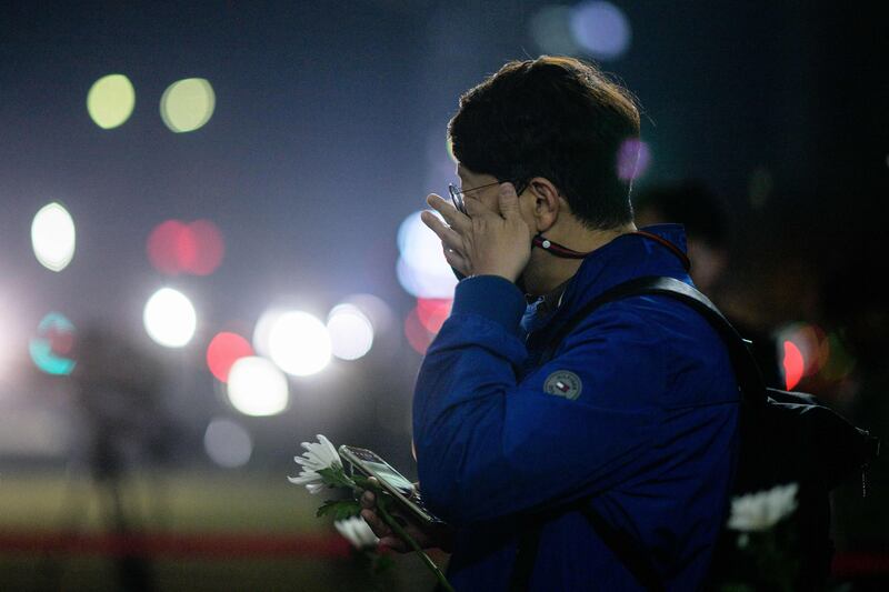 A man wipes away tears has he prepares to pay tribute in front of a joint memorial altar for victims of the crowd surge. Photograph: Anthony Wallace/AFP/Getty Images