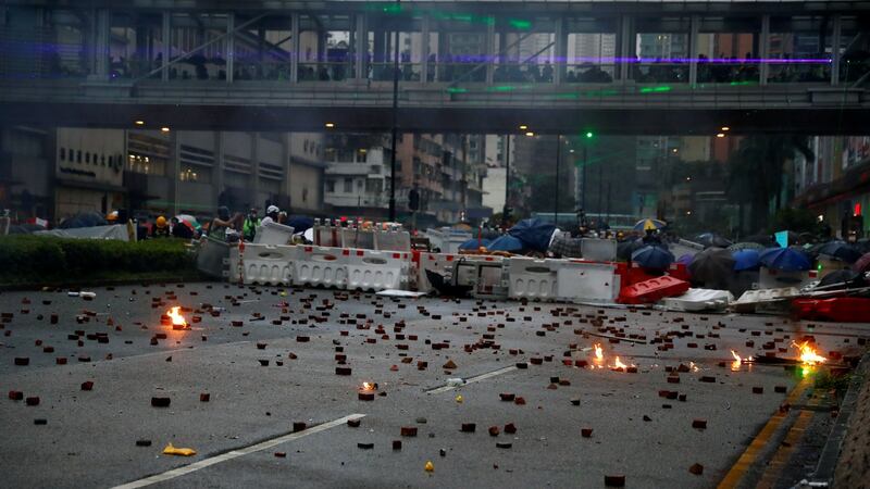 Demonstrators take shelter behind a barricade during a protest in Tsuen Wan, in Hong Kong on Sunday. Photograph:  Reutters