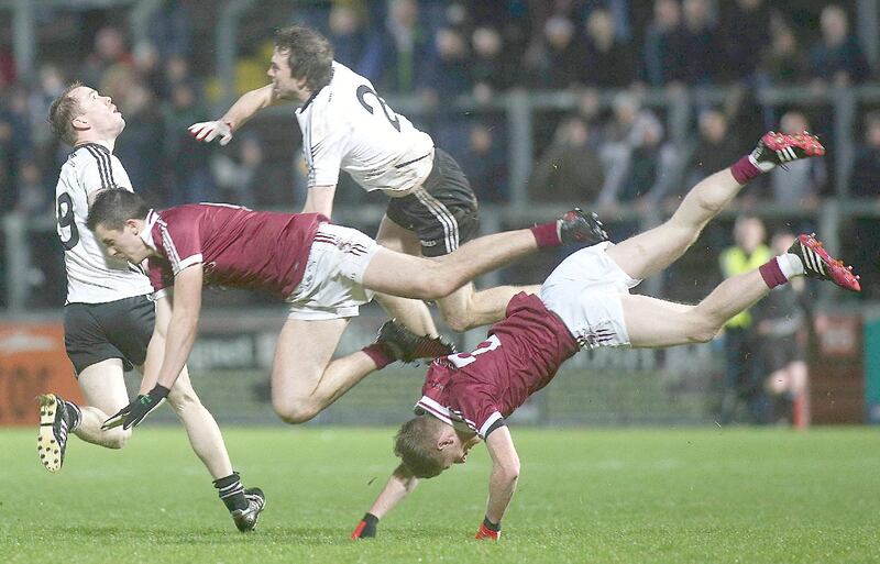 Slaughtneil's Shane McGuigan and Ronan Bradley clash with Omagh's Cormac O'Neill. Photograph: Lorcan Doherty/Inpho