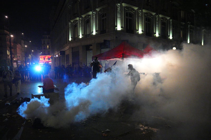 A man sits in a cloud of tear gas during a protest following the legislative election results in Paris, France. Photograph: Carl Court/Getty Images