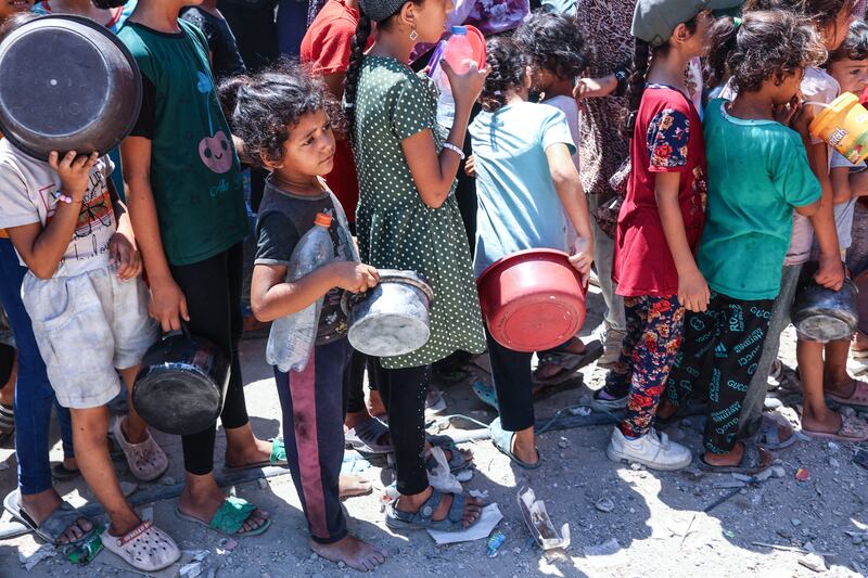 Palestinian children queue with containers at a food distribution point in the Jabalia refugee camp, northern Gaza Strip, on August 21st, 2024. Photograph: Omar Al-Qattaa/AFP/Getty