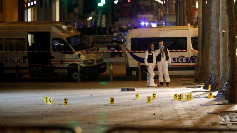 Forensic experts investigate the crime scene after a fatal shooting in which a police officer was killed along with an attacker on the Champs Elysees avenue in Paris. Photograph: Kamil Zihnioglu/AP Photo