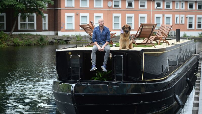Gary Long with his dog, Kimba, on his barge moored on the Grand Canal in Dublin. Photograph: Dara Mac Dónaill