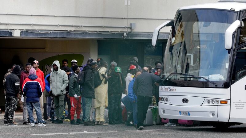 Migrants wait to board a bus to leave the Castelnuovo di Porto refugee centre.  Photograph: Andrew Medichini