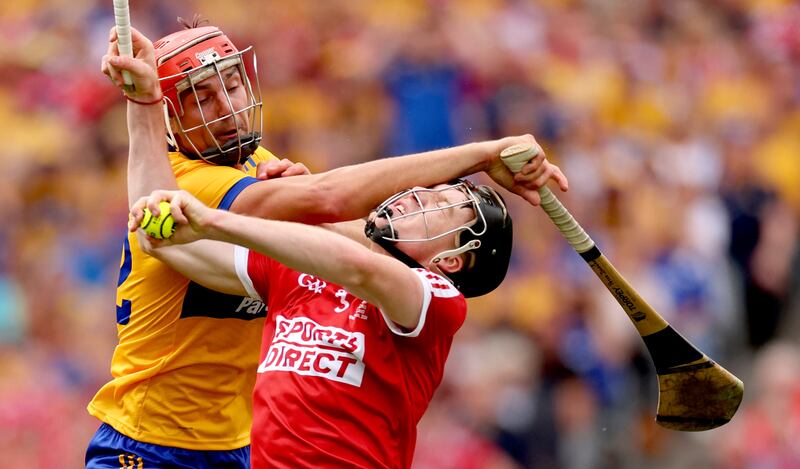 Clare’s Peter Duggan and Eoin Downey of Cork clash for possession.
Photograph: James Crombie/Inpho