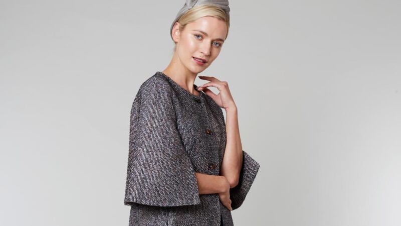 Cape  coat with wide cape sleeves and an A-line silhouette. Worn here with matching knee-length skirt. Approx €1,400.