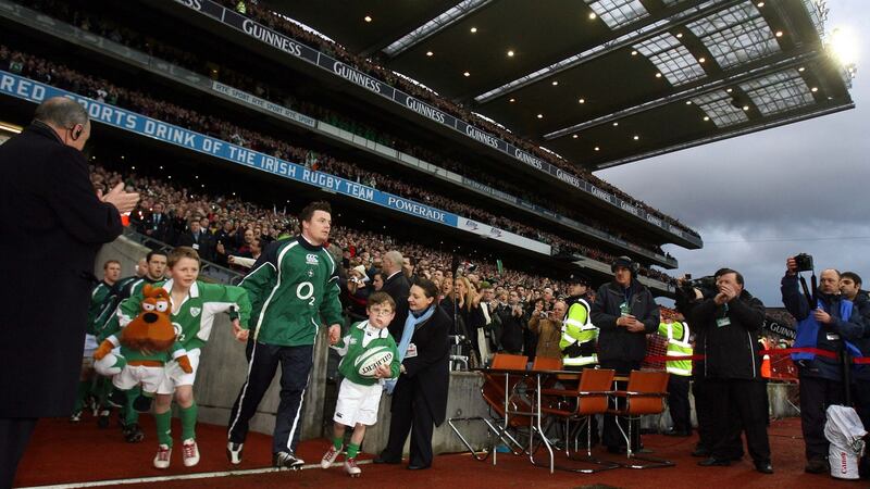Captain Brian O’Driscoll leads Ireland out for the England game alongside mascots Charlie McMickan (left) and Daniel Moloney. Photograph: Dan Sheridan